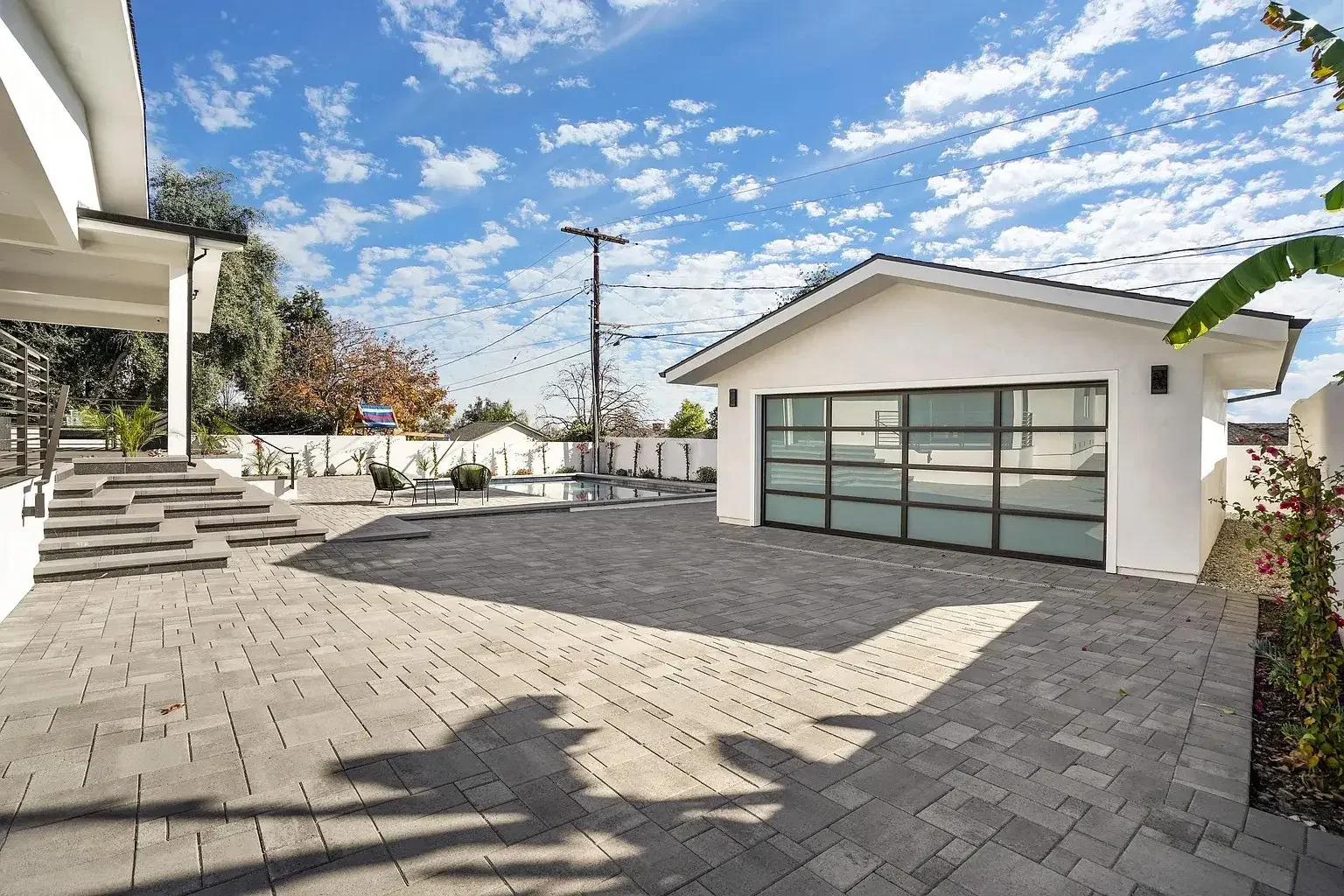Detached structure opening onto a paved residential courtyard