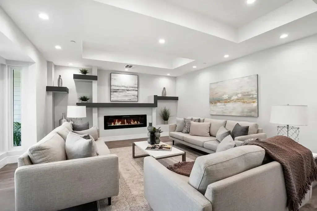 Open living room with a fireplace and kitchen in the background