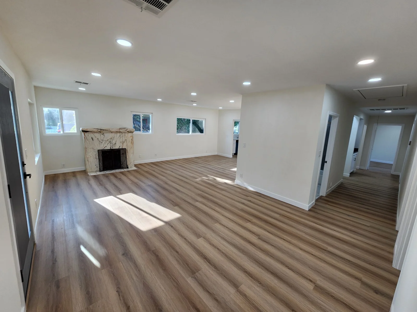 Open renovated interior with wood-look flooring and recessed lighting