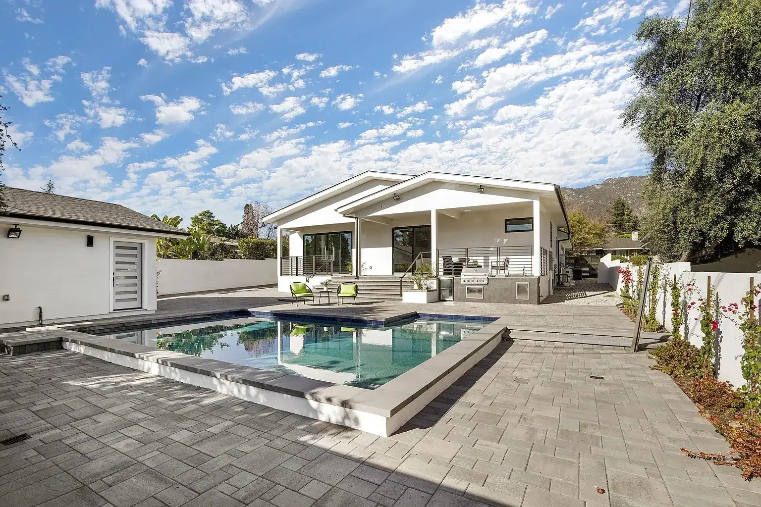 Pool and raised spa beside a covered outdoor seating area